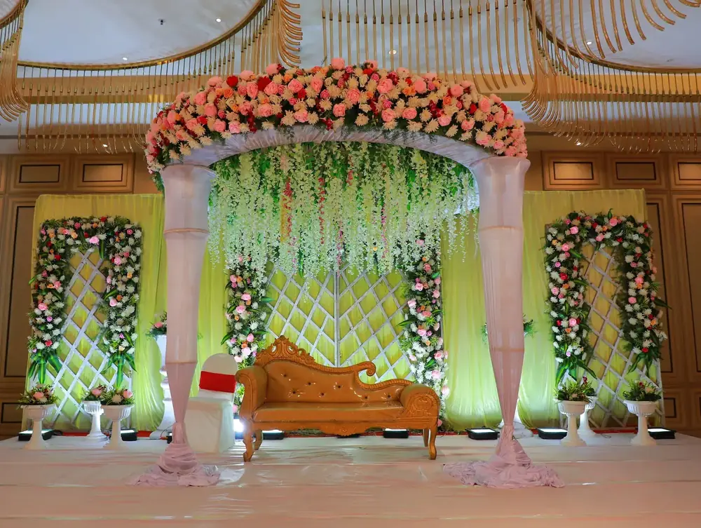 Wedding stage with a floral arch and flower panels
